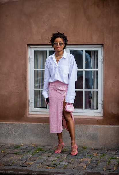COPENHAGEN, DENMARK - AUGUST 10: A guest is seen wearing pink skirt, white button shirt outside Love...