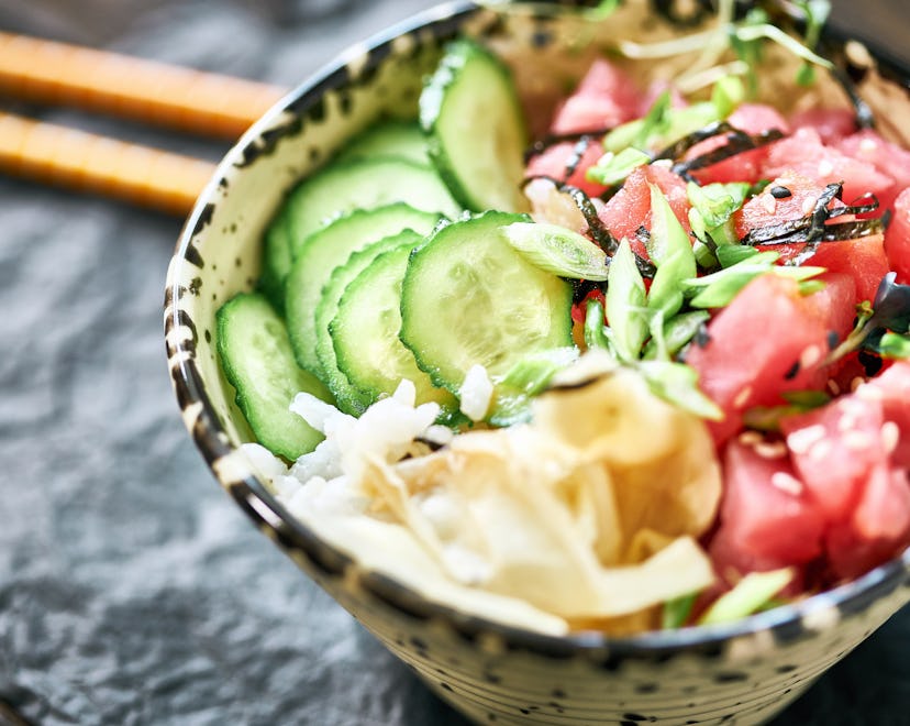 Sliced raw tuna, rise and vegetables in bowl