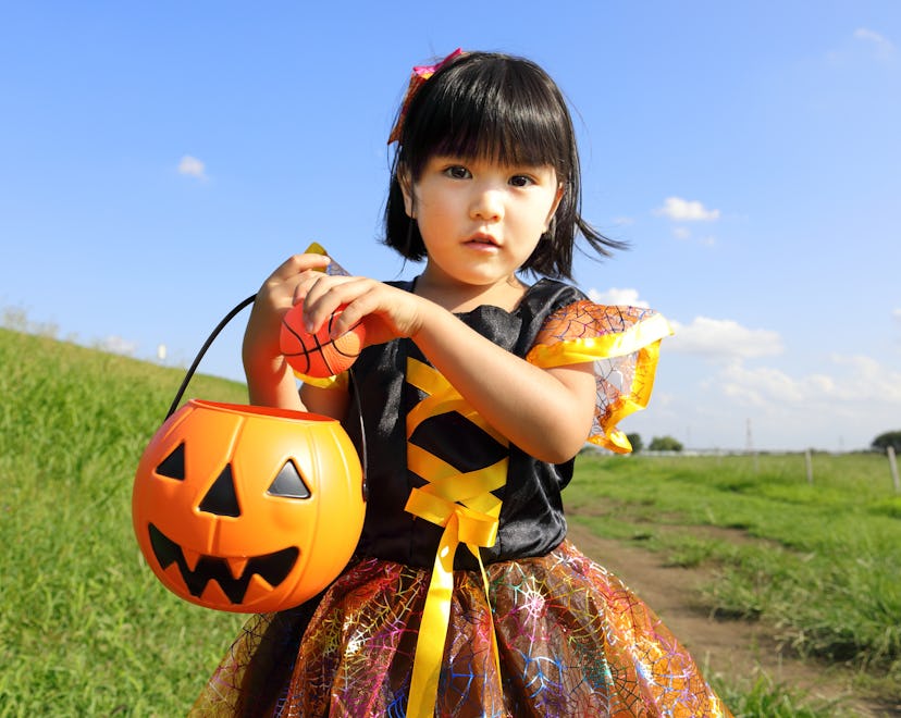 little girl dressed up in halloween costume standing outside