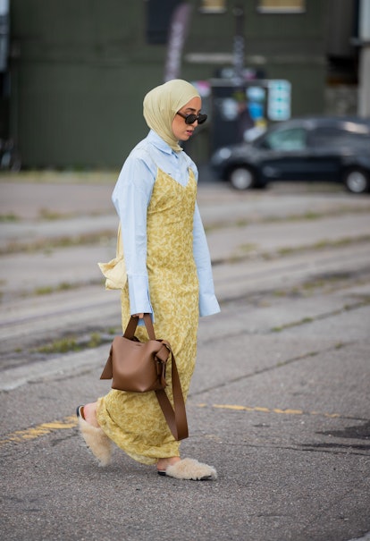 COPENHAGEN, DENMARK - AUGUST 11: A guest is seen wearing head scarf, dress, brown bag outside Samsøe...