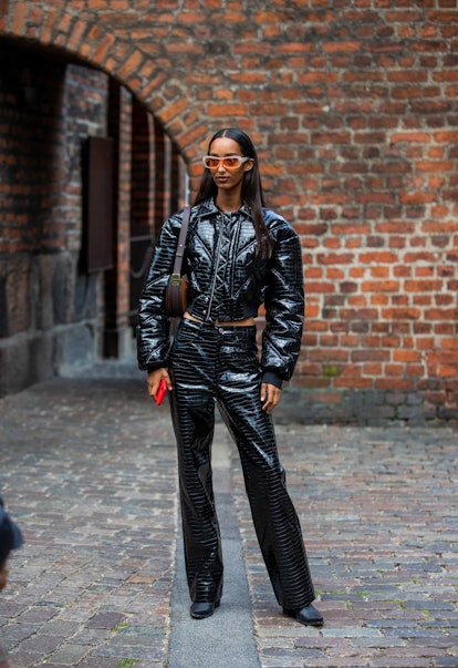 COPENHAGEN, DENMARK - AUGUST 10: A guest ist seen wearing black cropped jacket and pants latex outsi...