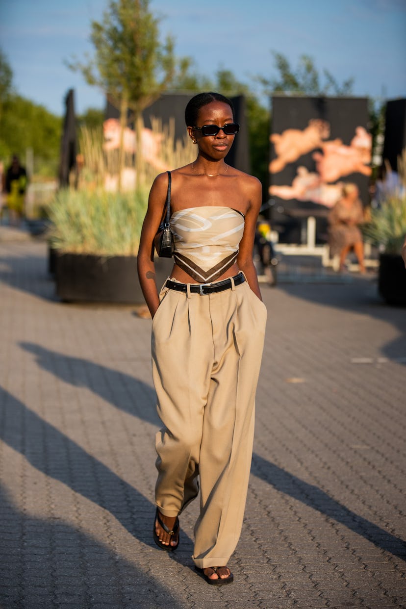 COPENHAGEN, DENMARK - AUGUST 12: A guest is seen wearing beige pants, cropped top outside Rotate on ...