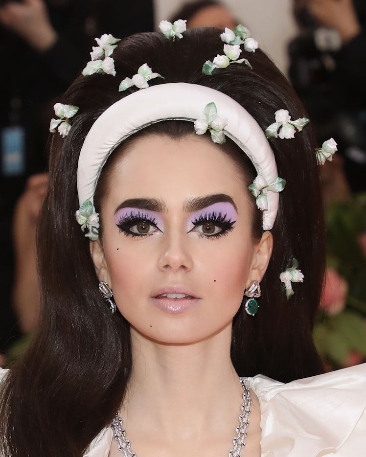 Lily Collins attends the 2019 Met Gala celebrating "Camp: Notes on Fashion" wearing a complete purpl...