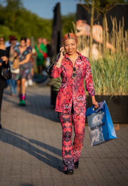 COPENHAGEN, DENMARK - AUGUST 12: A guest is seen wearing red button shirt and pants with print outsi...