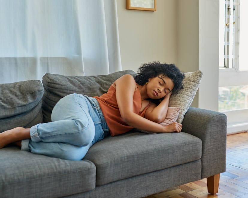 Shot of a young woman sleeping on a sofa at home