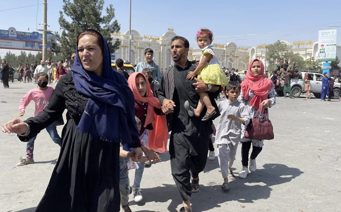 KABUL, AFGHANISTAN-AUGUST 16: An Afghan family rushes to the Hamid Karzai International Airport as t...