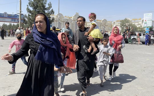 KABUL, AFGHANISTAN-AUGUST 16: An Afghan family rushes to the Hamid Karzai International Airport as t...