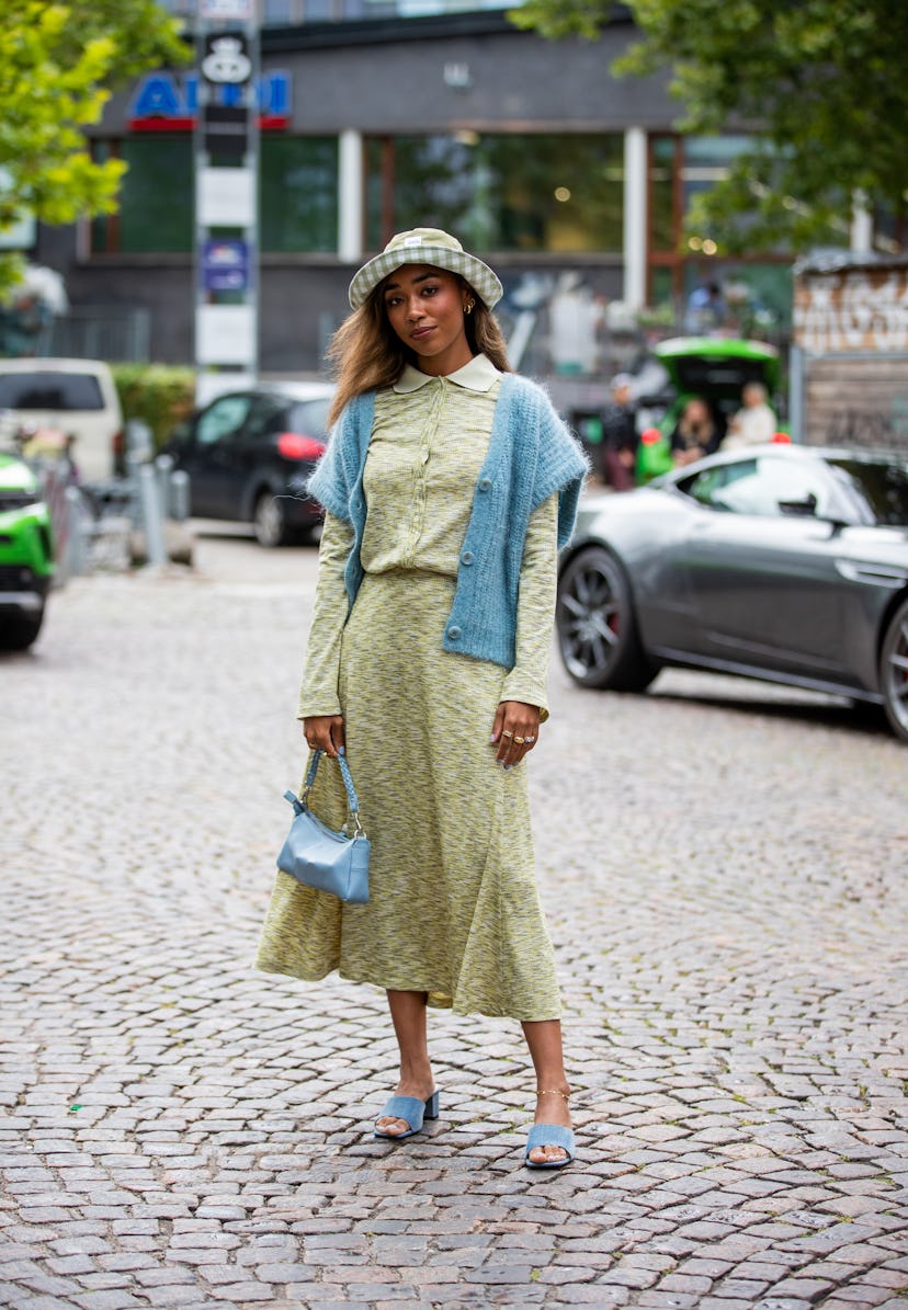 COPENHAGEN, DENMARK - AUGUST 10: A guest is seen wearing green skirt and button shirt, hat outside 7...