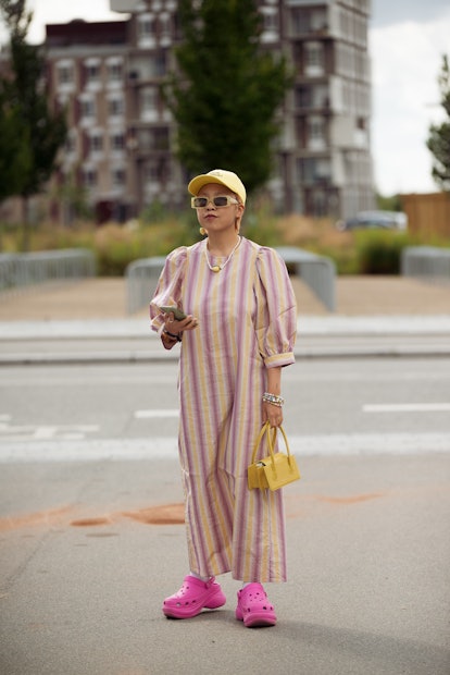 COPENHAGEN, DENMARK - AUGUST 11: Guest wearing long striped dress, yellow hat and pink shoes  outsid...
