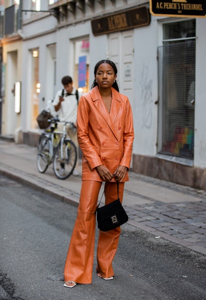 COPENHAGEN, DENMARK - AUGUST 10: A guest is seen wearing orange brown jacket and pants outside Soere...