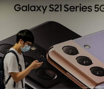 HONG KONG, CHINA - 2021/05/18: A man uses a smartphone as he walks past the South Korean multination...