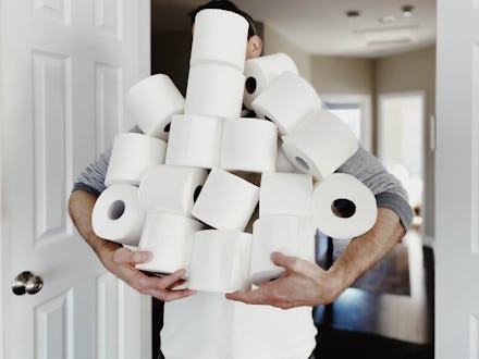 Close-up of unrecognizable man carrying an abundance of toilet paper