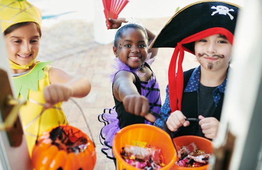 three kids trick-or-treating on halloween