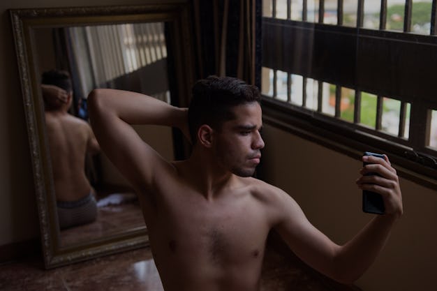 Brandon Mena takes pictures of himself on a mirror with his cellphone, to make content for his OnlyF...