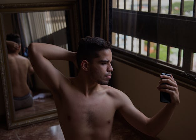 Brandon Mena takes pictures of himself on a mirror with his cellphone, to make content for his OnlyF...