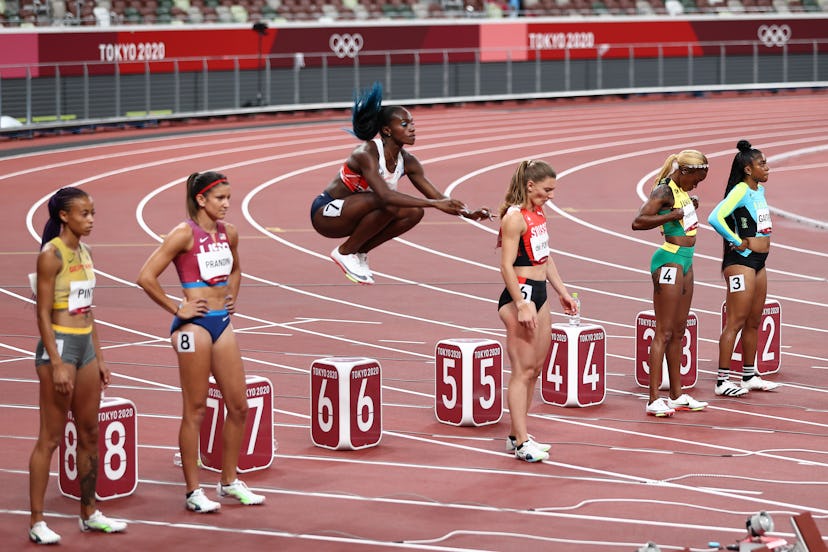 TOKYO, JAPAN - JULY 31: Dina Asher-Smith (C) of Team Great Britain warms up on the blocks during the...