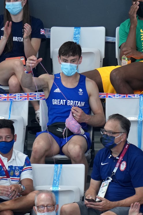 Great Britain's Tom Daley knits in the stands during the Women's 3m Springboard Final at the Tokyo A...