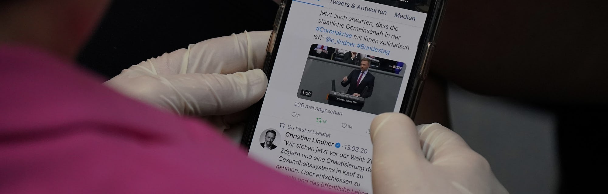 BERLIN, GERMANY - MARCH 25: A member of the Bundestag wears protective gloves as she follows a Twitt...
