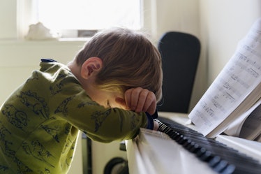 child at piano thinking about music