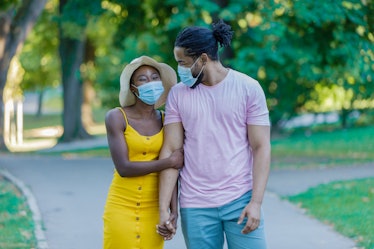 An African-American Woman and Her Lovely Husband are Walking in the Public Park with Protective Mask...