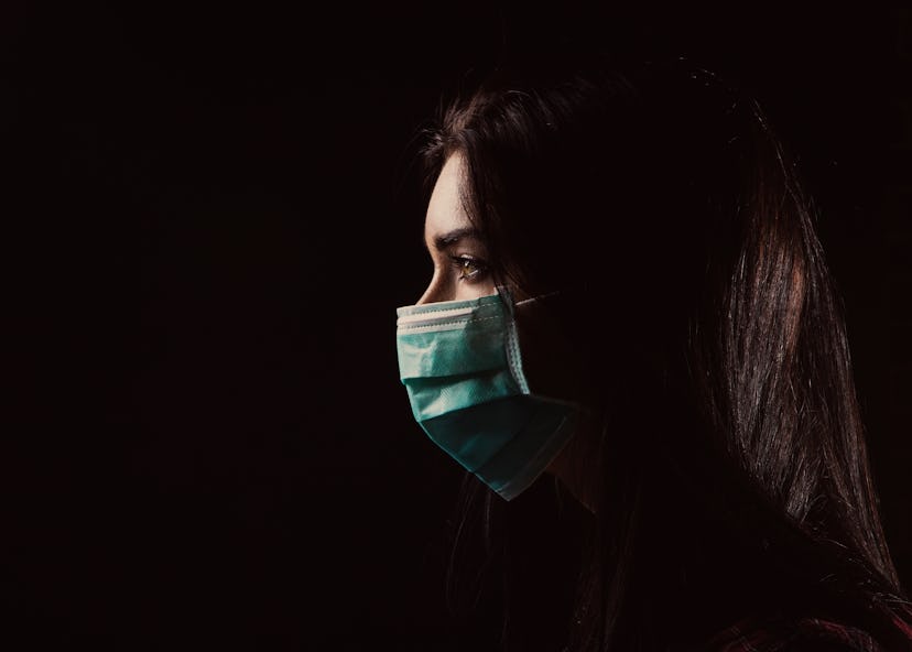 Portrait in profile of a beautiful woman in a mask on a black background