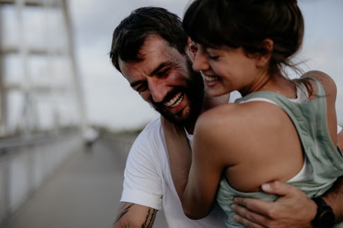 Close-up image of a romantic bonding couple doing sport together on the street. Having fun after a m...