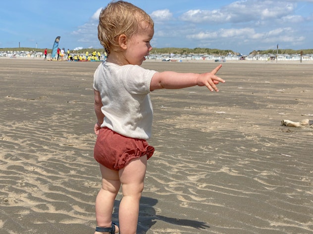 Baby girl at the IJmuiden beach on a warm sunny day