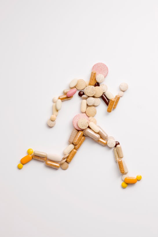 athletic runner shape made of vitamin pills viewed from above 