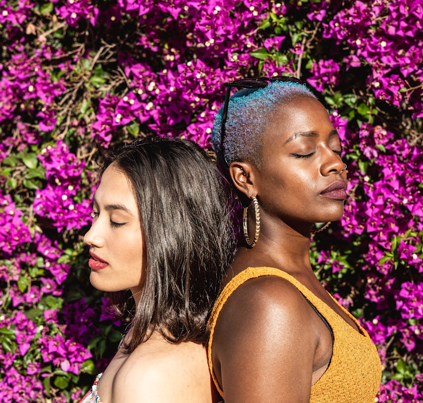 young women with their backs together and eyes shut, thinking about libra scorpio compatibility