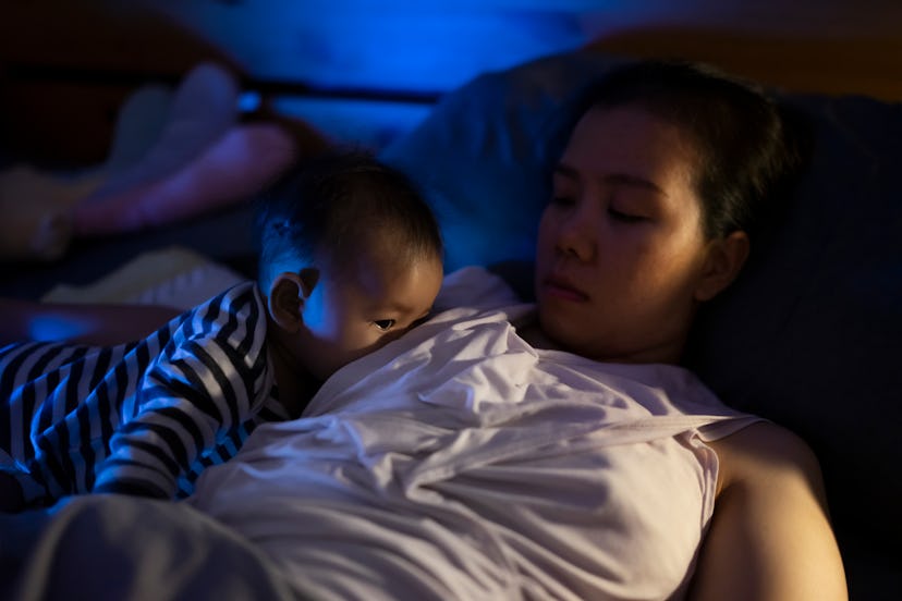 baby nursing at night, while mother shares a breastfeeding photo with caption
