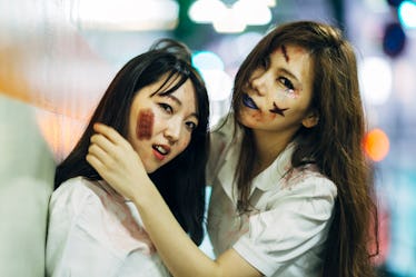 Two lesbians dress up in Halloween costumes.
