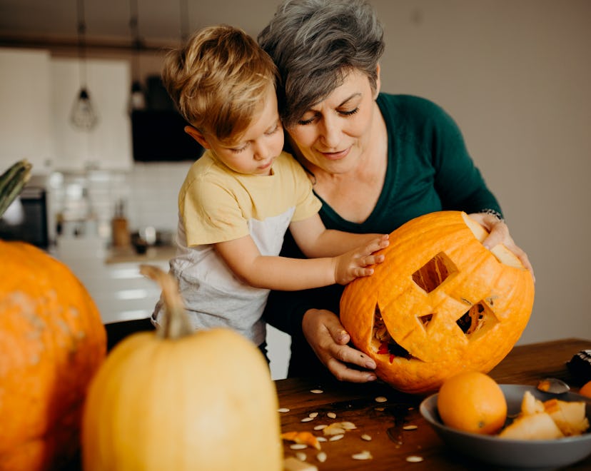 a mom and her son making a jack o'lantern