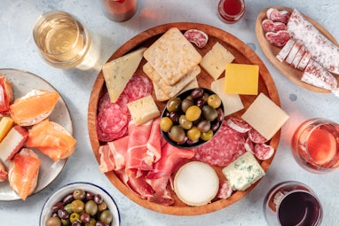 Charcuterie and cheese board with wine, overhead flat lay shot. Italian antipasti or Spanish tapas, ...