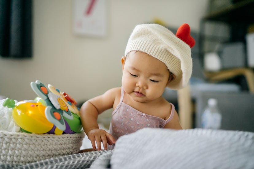 cute baby boy in hat plays with toys