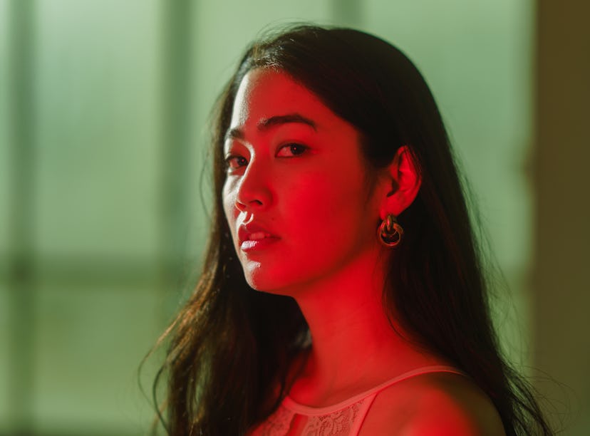 A portrait of a woman lit by vibrant neon colored lights during the September 2021 full moon in Pisc...