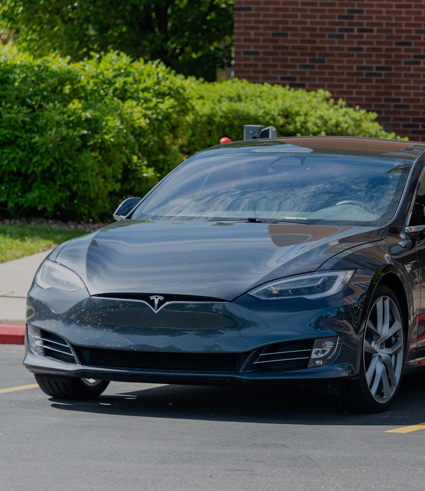 Tesla electric car being charged at a charging station located in the parking lot of a Cambria Suite...