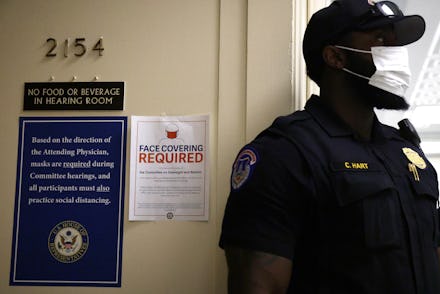 WASHINGTON, DC - JULY 29: A U.S. Capitol Police officer wears a mask as signs regarding the new fac...