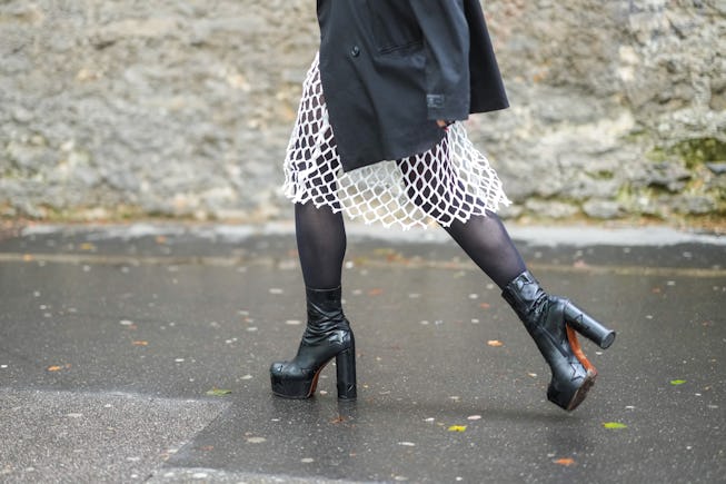 PARIS, FRANCE - JULY 04: A guest wears a black oversized blazer jacket, black tights, a white mesh k...