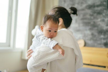 baby getting burped in mother's arms