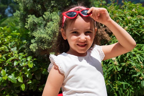 Little girl dressed in straw hat and red sunglasses.portrait
