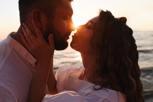 Young couple kissing at sunset. Attitude and love.