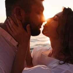Young couple kissing at sunset. Attitude and love.