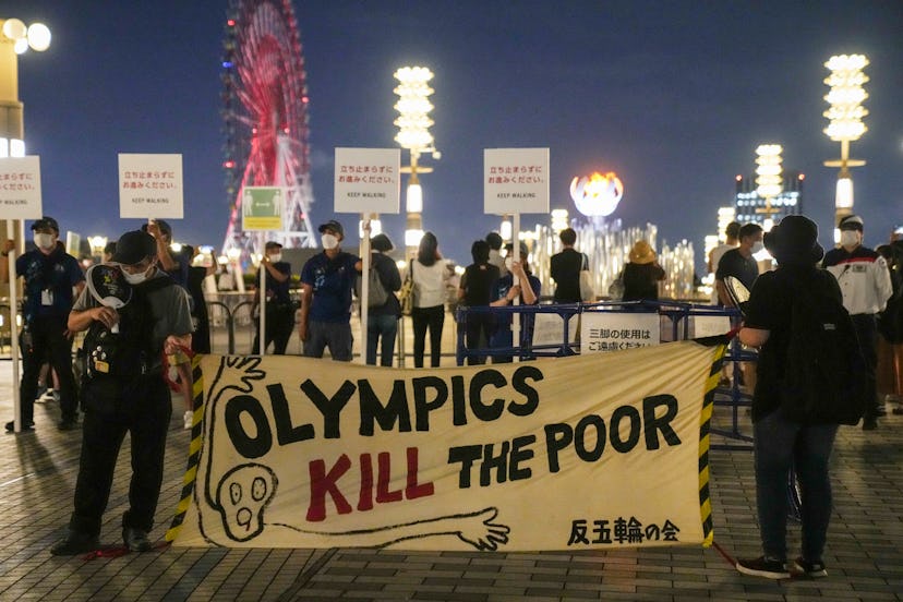 TOKYO, JAPAN - JULY 29: People hold placards during an anti-Olympics protest in front of Tokyo 2020 ...