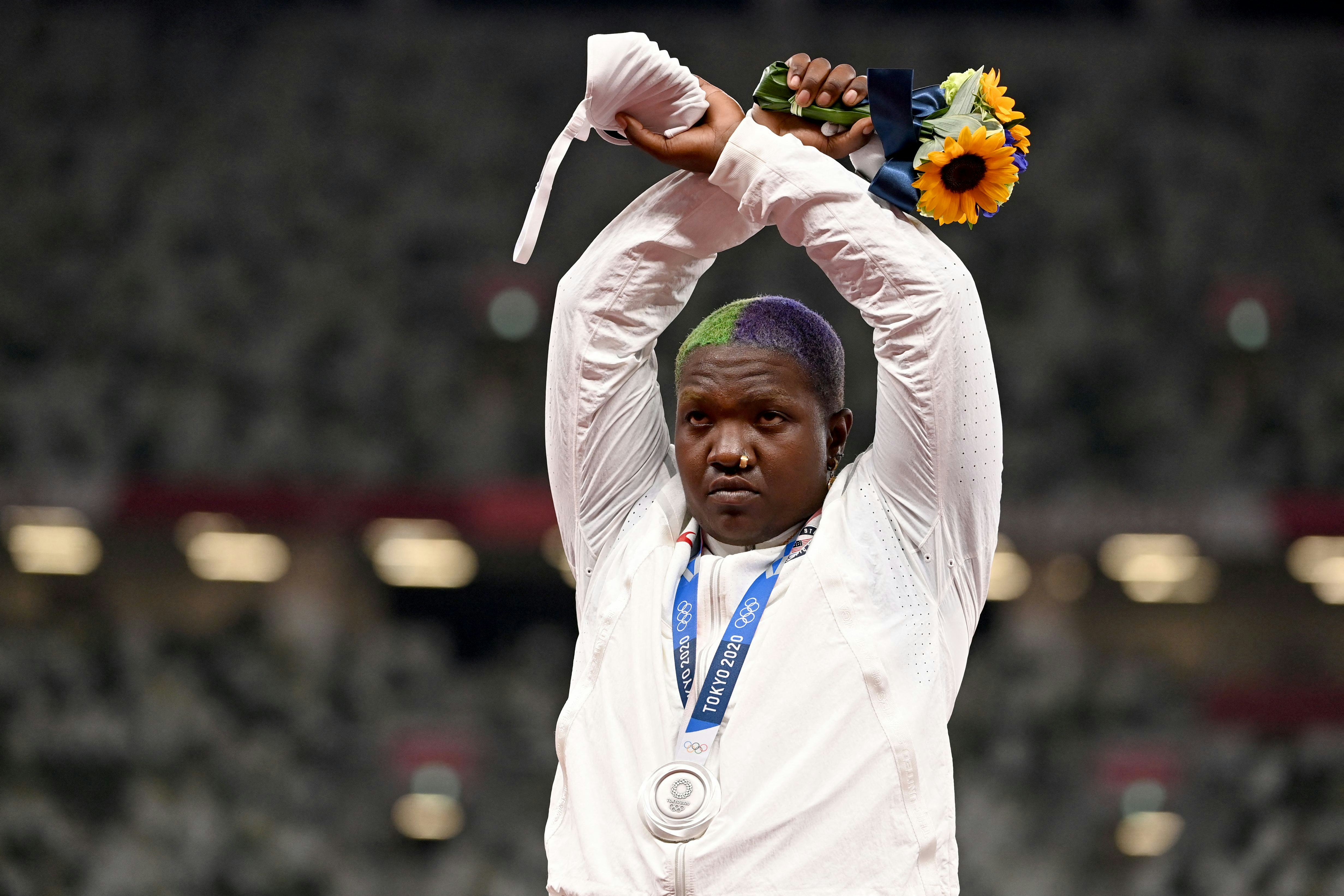 Raven Saunders makes an 'X' with her wrists on the podium of the women's shot put event after receiv...