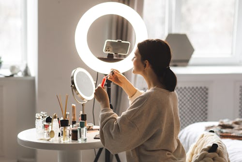 A woman sits in front of a ring light preparing to go live on TikTok. Why can't I go live on TikTok?...