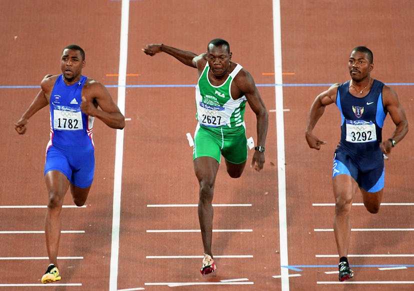 (L to R) Britain's Darren Campbell, Nigerian Aliu Deji and US Curtis Johnson finish their heat 5 of ...