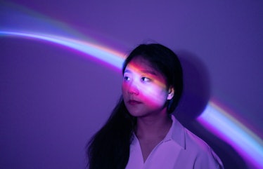 Young woman in purple neon lights during Mercury retrograde fall 2021.