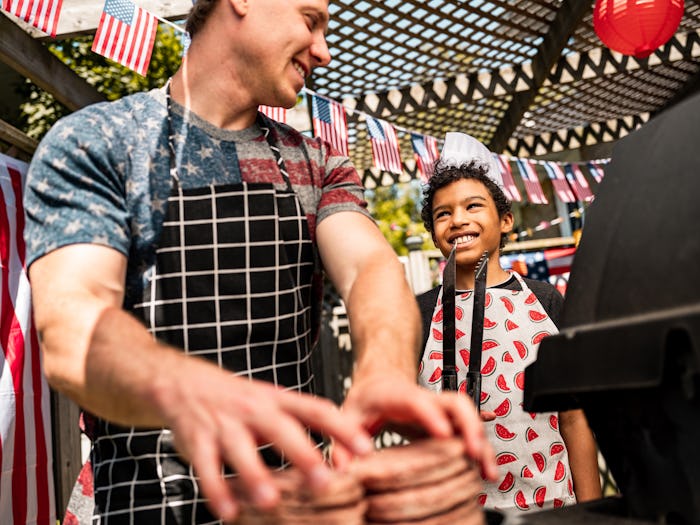 Young man and boy teenager setting up a BBQ grill for outdoor labor day celebration