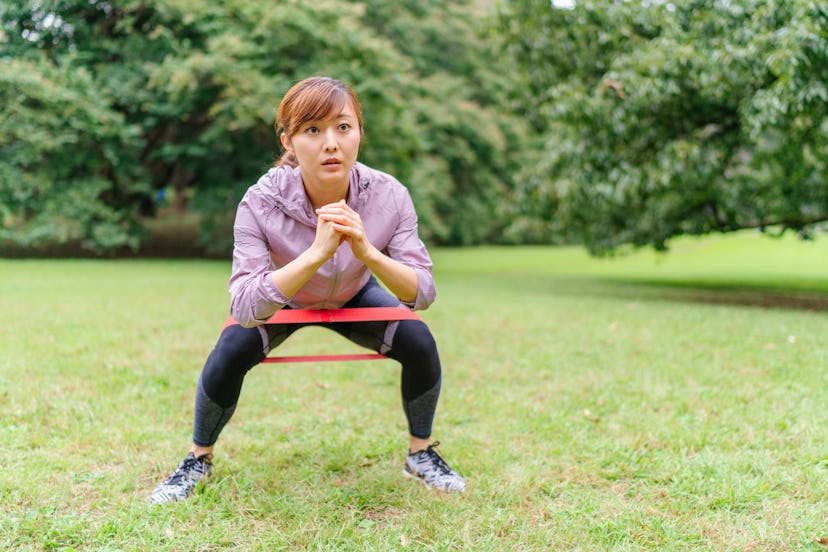 Squatting with a resistance band is a great way to build lower body strength and stability.