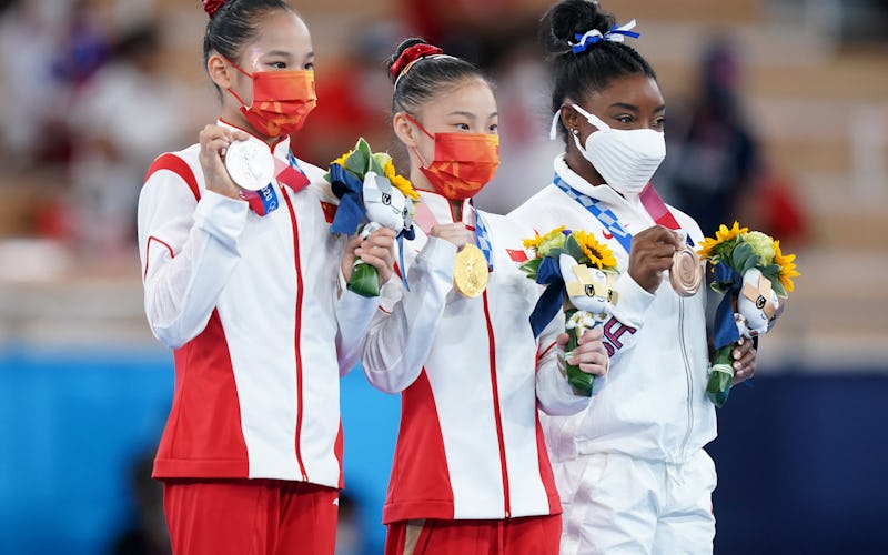 Xijing Tang, Chenchen Guan, and Simone Biles pose together after accepting their medals in the women...